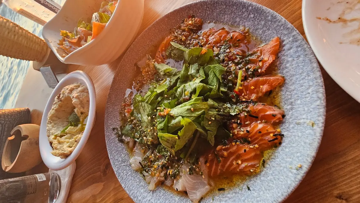 11 Best Lebanon Restaurants: A Food Critic's Guide 8 Diners enjoy drinks and food on the seaside terrace of Pierre and Friends restaurant in Batroun during sunset.