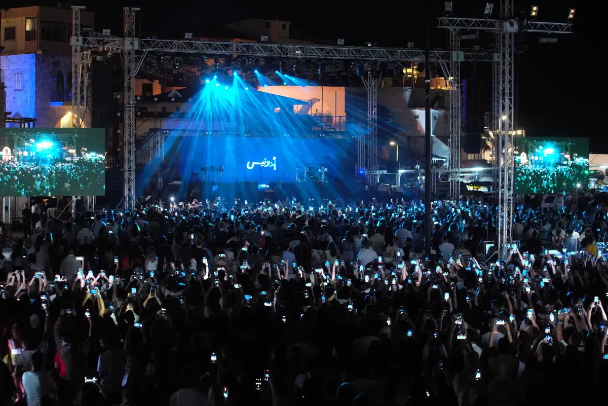 Batroun old town streets with outdoor art exhibitions and tourists during summer Lebanon festivals.